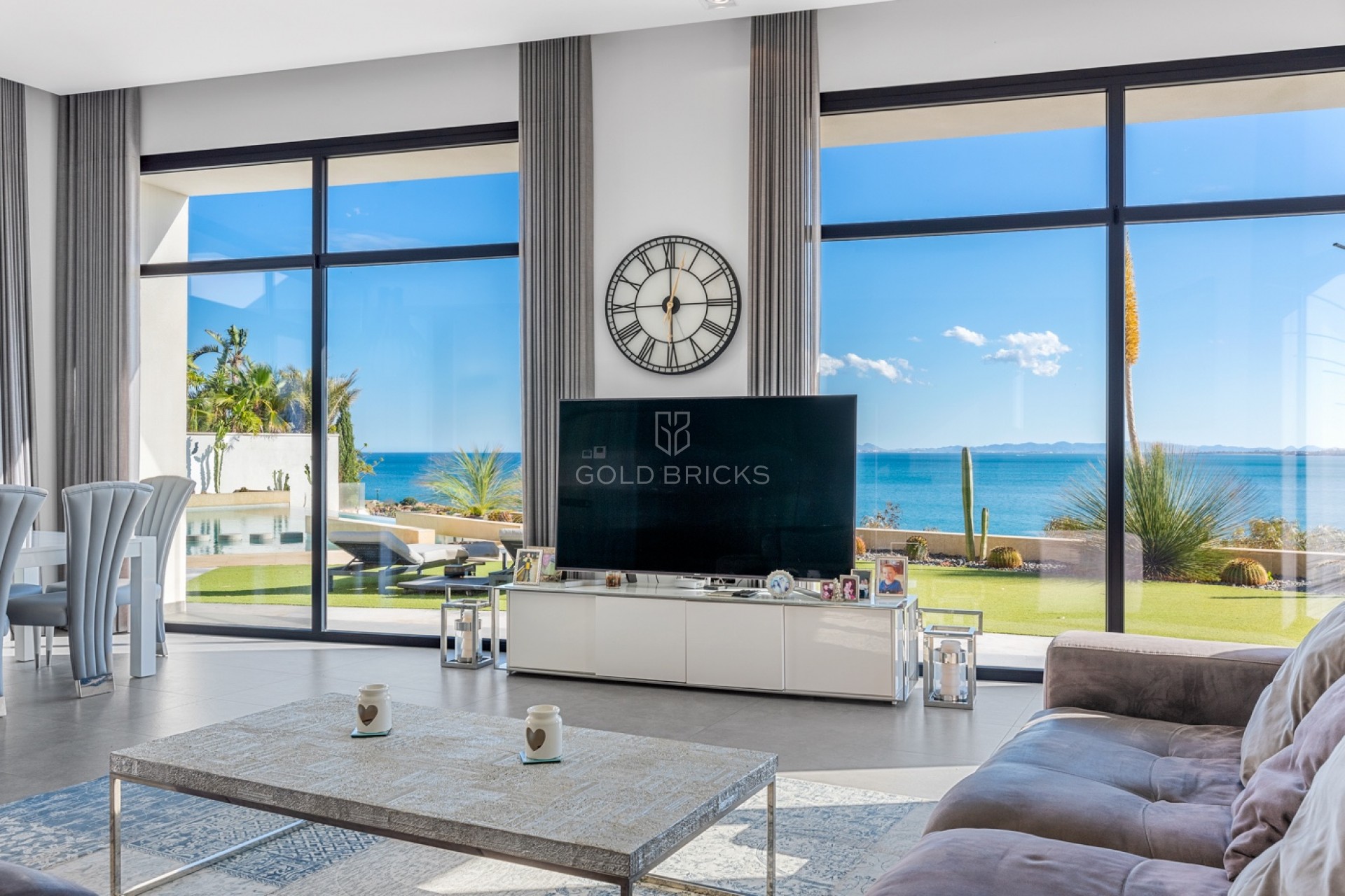 Salón de la villa de Cabo Roig con ventanales al jardín y al mar